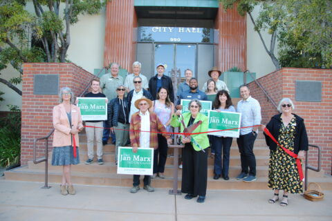 Group of people taking a ribbon cuttig photo in from of City of SLO Government Council Building