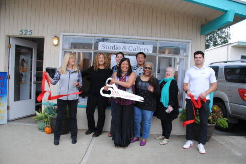 Group of people celebrating a ribbon cutting in front of studio in Morro Bay, Ca
