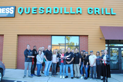 group photo in front of Press Quesadilla Grill posing for ribbon cutting photo