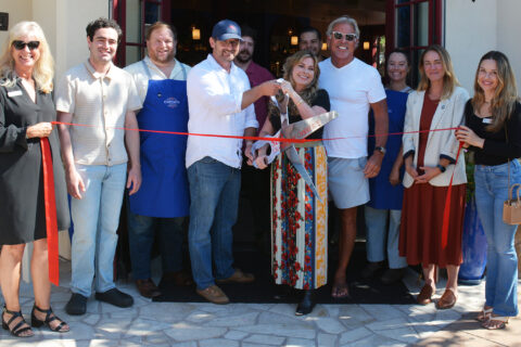 group of people celebrating a ribbon cutting in front of Petit Soleil, a boutiques Hotel in SLO, California.