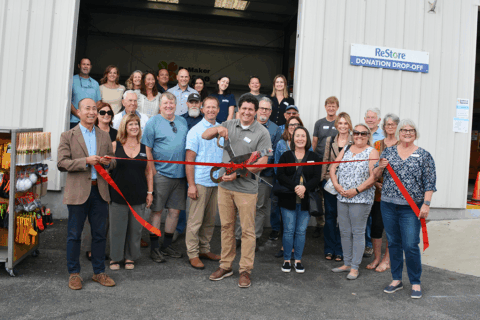 Group of people posing for a photo in front of Habit SLO's Restore, a new DIY ReMaker space.