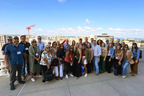 Group of people posing for picture on top of a rooftop building