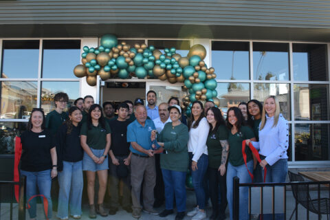 Group of people posing for a ribbon cutting photo in front of Petras Mediterranean Pizza & Grill in San Luis Obispo