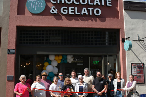 group shot of people celebrating Tifa with a ribbon cutting